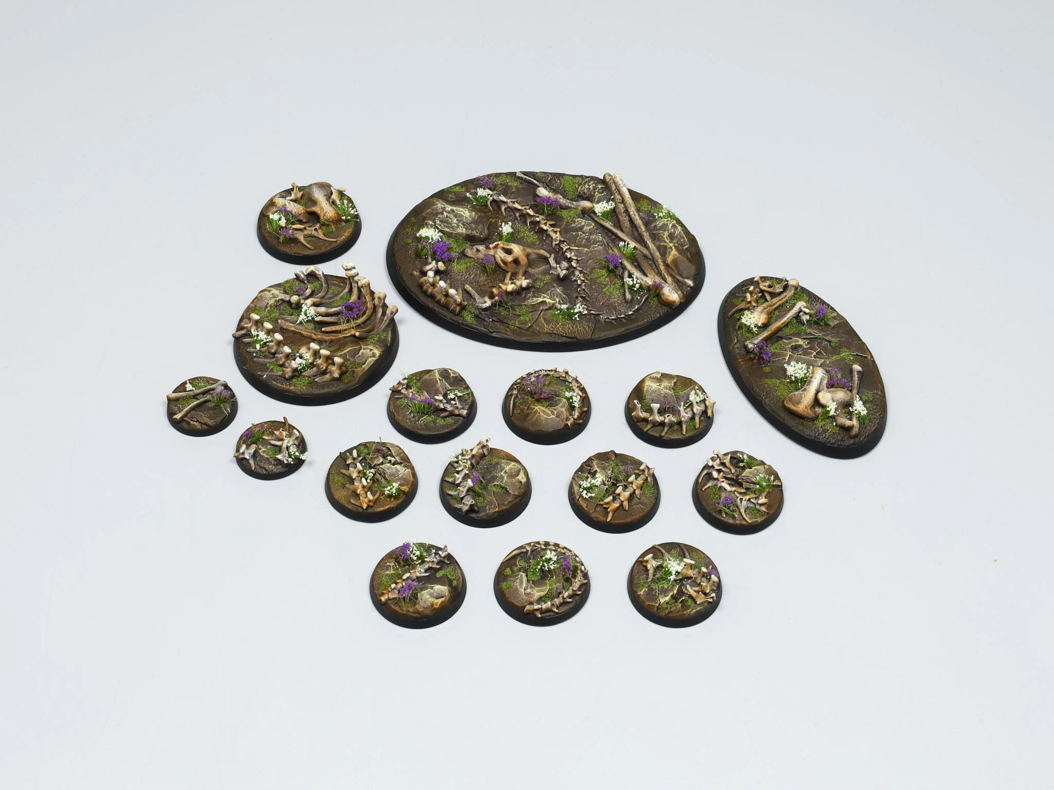 Red cracked-earth miniature bases with skeleton fragments and dry vegetation