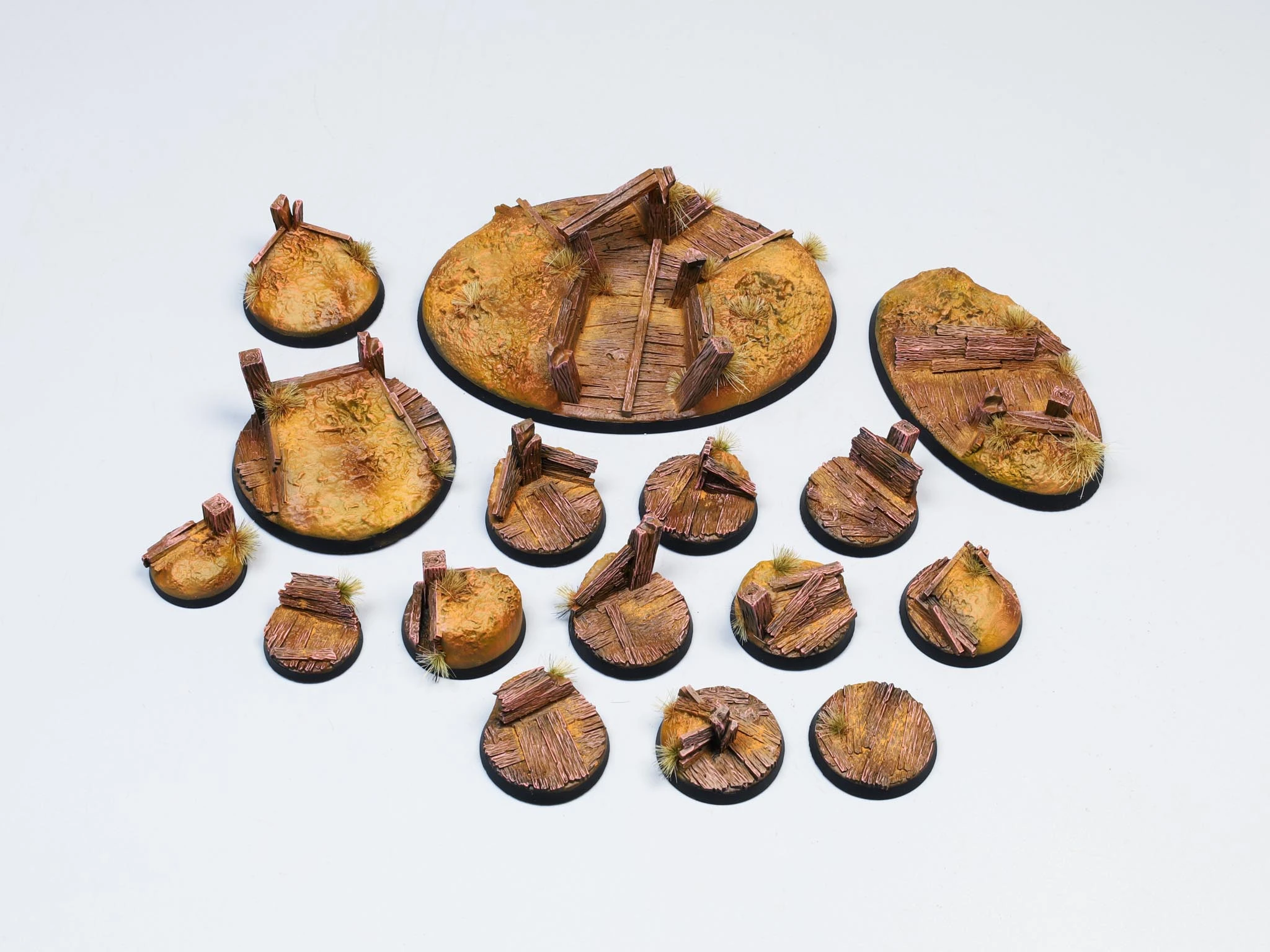 Red cracked-earth miniature bases with skeleton fragments and dry vegetation