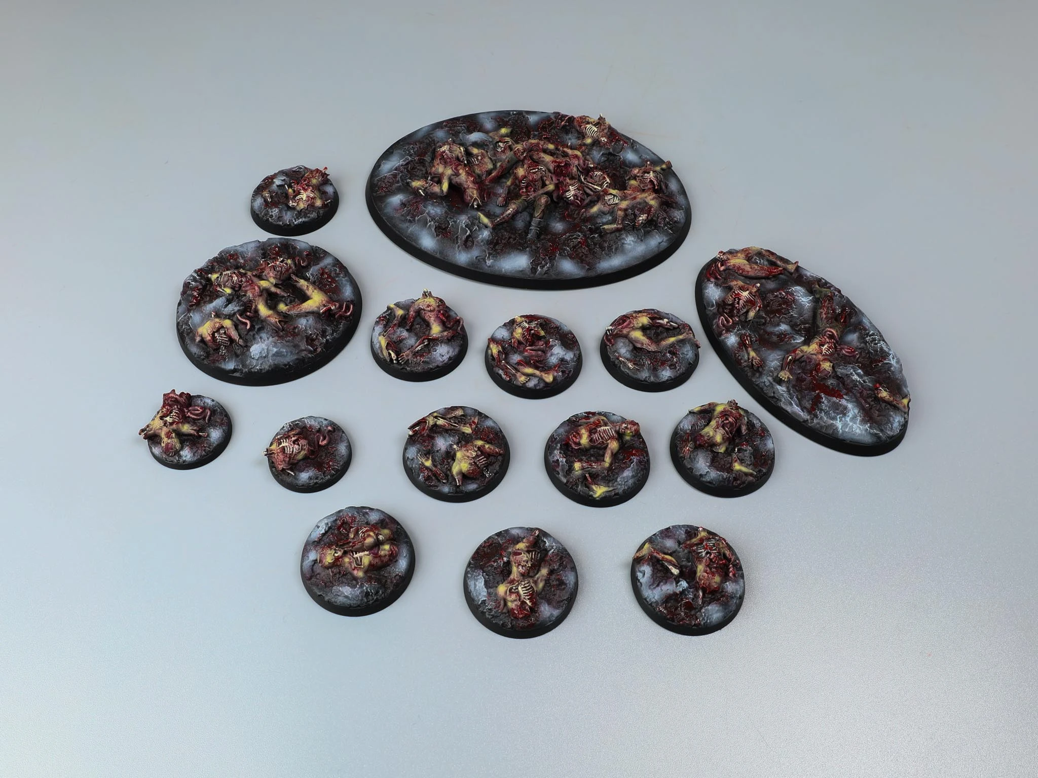 Red cracked-earth miniature bases with skeleton fragments and dry vegetation